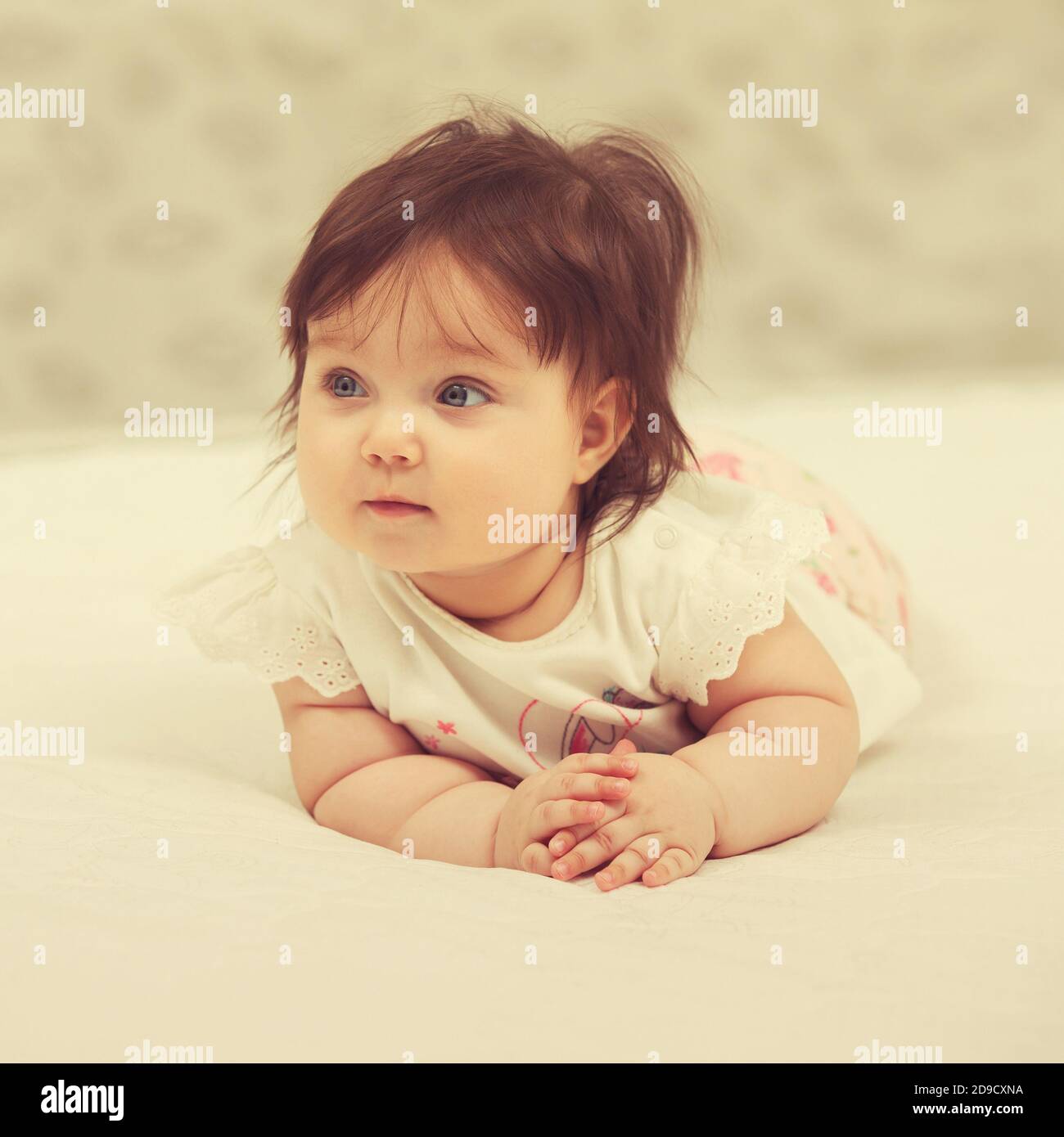 Happy six months old baby girl lying on blanket at home Stock Photo Alamy