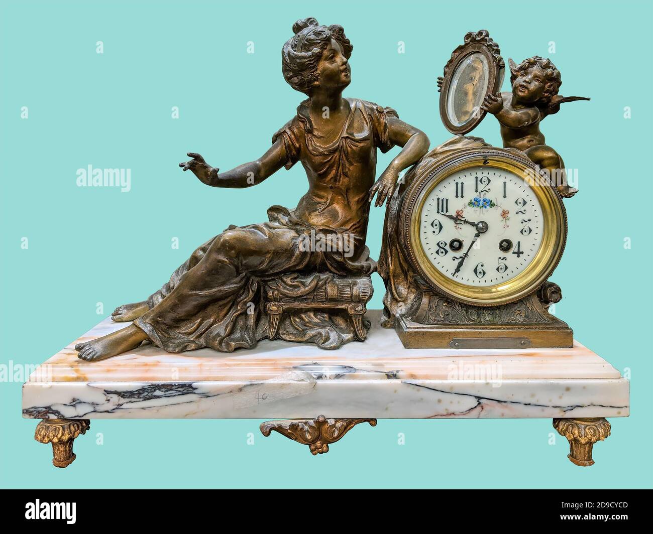 Antique mantel clock of brass woman and little angel statuettes, on isolated green background with clipping path. Stock Photo