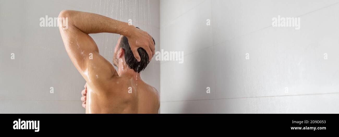 Taking a shower young man showering washing product shampoo from hair panorama banner home lifestyle background Stock Photo