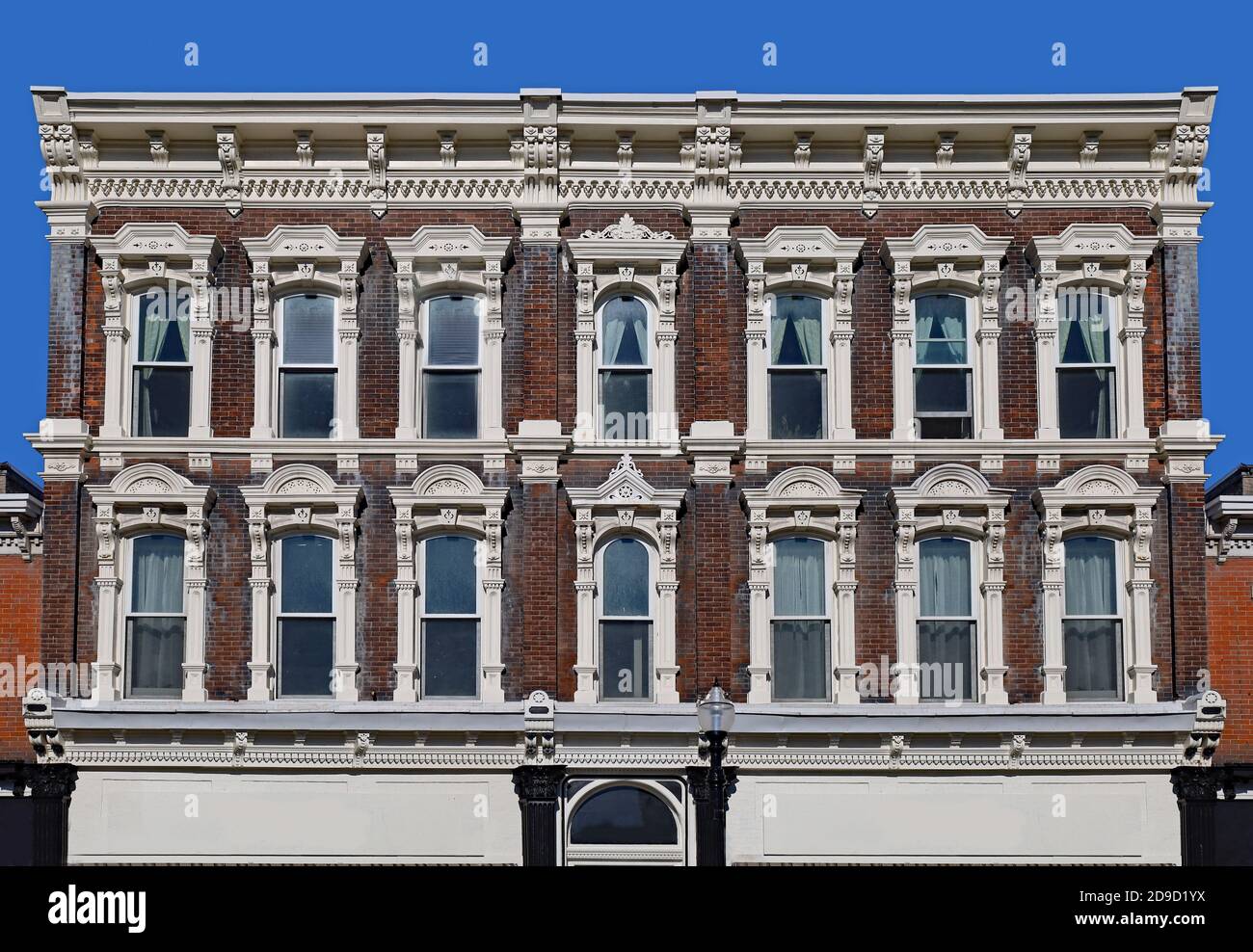 Old fashioned 19th century apartment building with ornamental trim around windows and roof Stock Photo