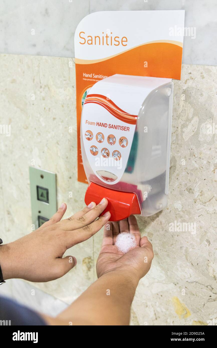 Person dispensing disinfectant sanitizer liquid onto hand at public amenities Stock Photo Alamy