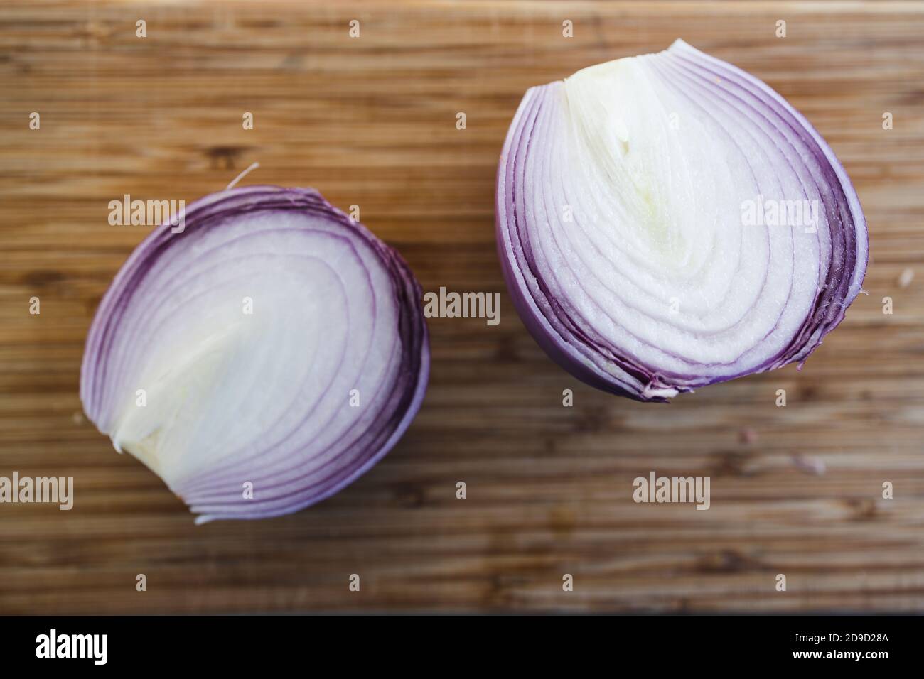 simple food ingredients concept, red onion cut in half on bamboo ...