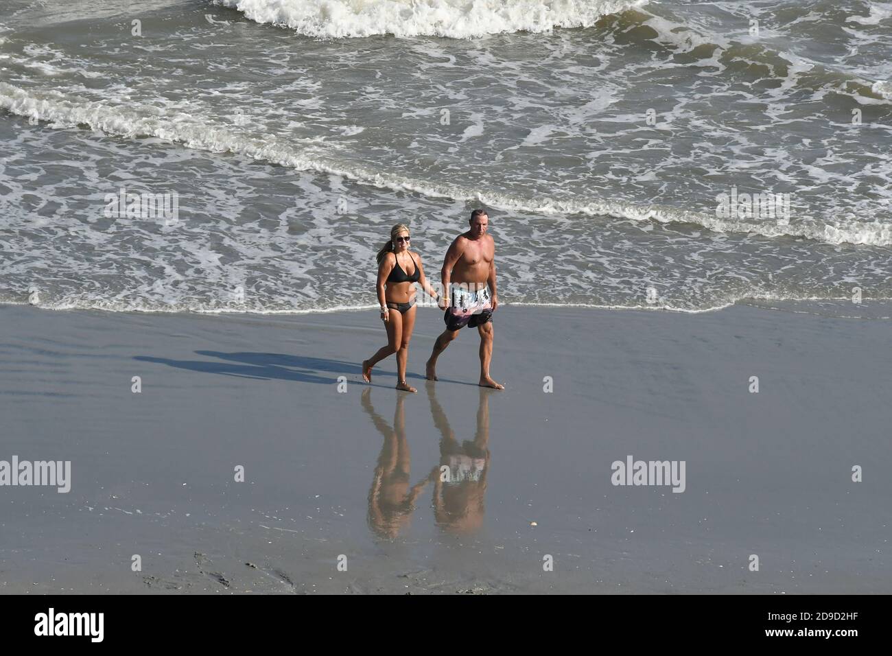 Older couple walking on the beach holding hands Stock Photo