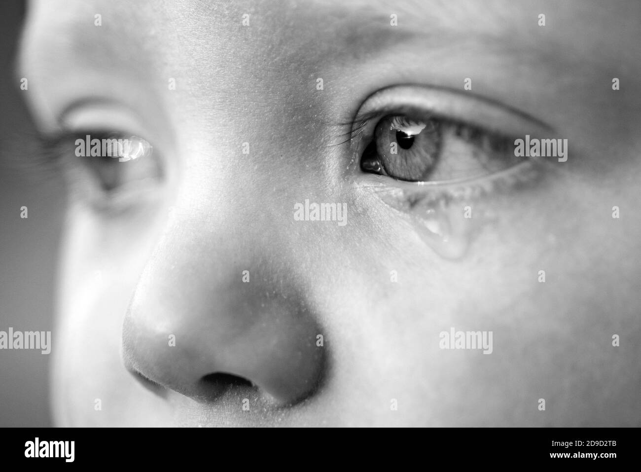 Cry baby with sky blue eyes. Little tender baby boy crying. Eye drop, tear drop of little sweetheart kid. Emotional baby miss his mom. Childhood Stock Photo