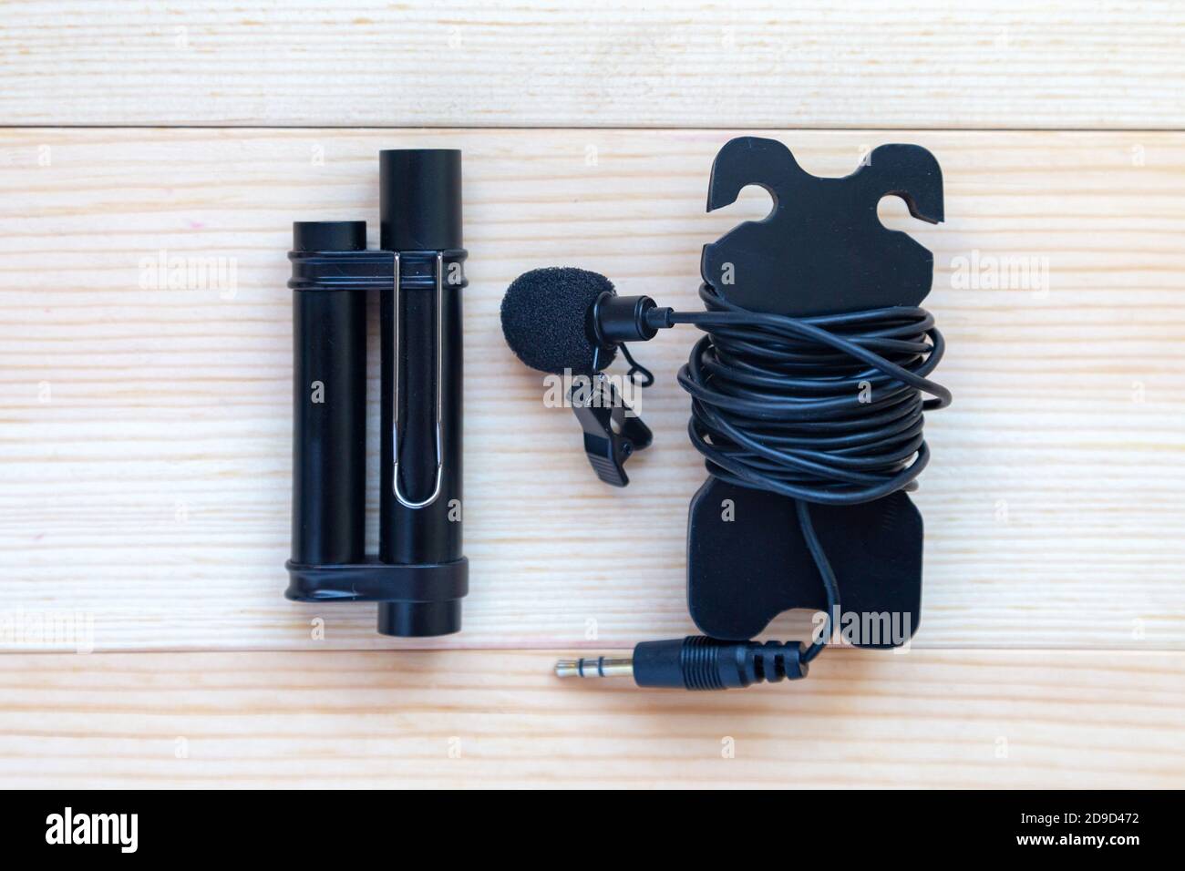 Lavalier microphone with long cable and power module. Wood background