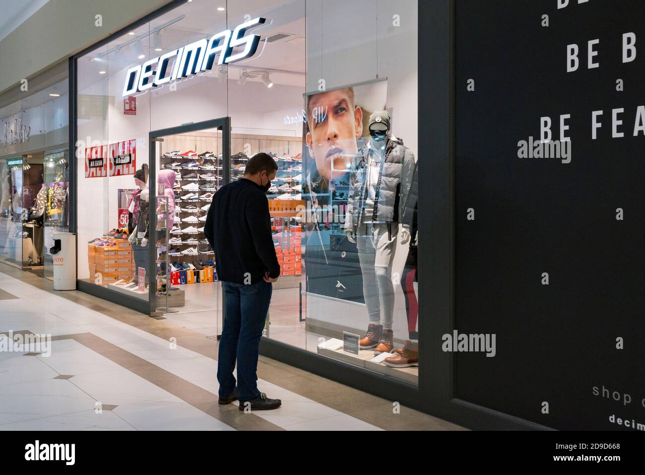 A man wearing a face mask looking at the clothes inside the Decimas store  at the Osito La Eliana shopping center Stock Photo - Alamy