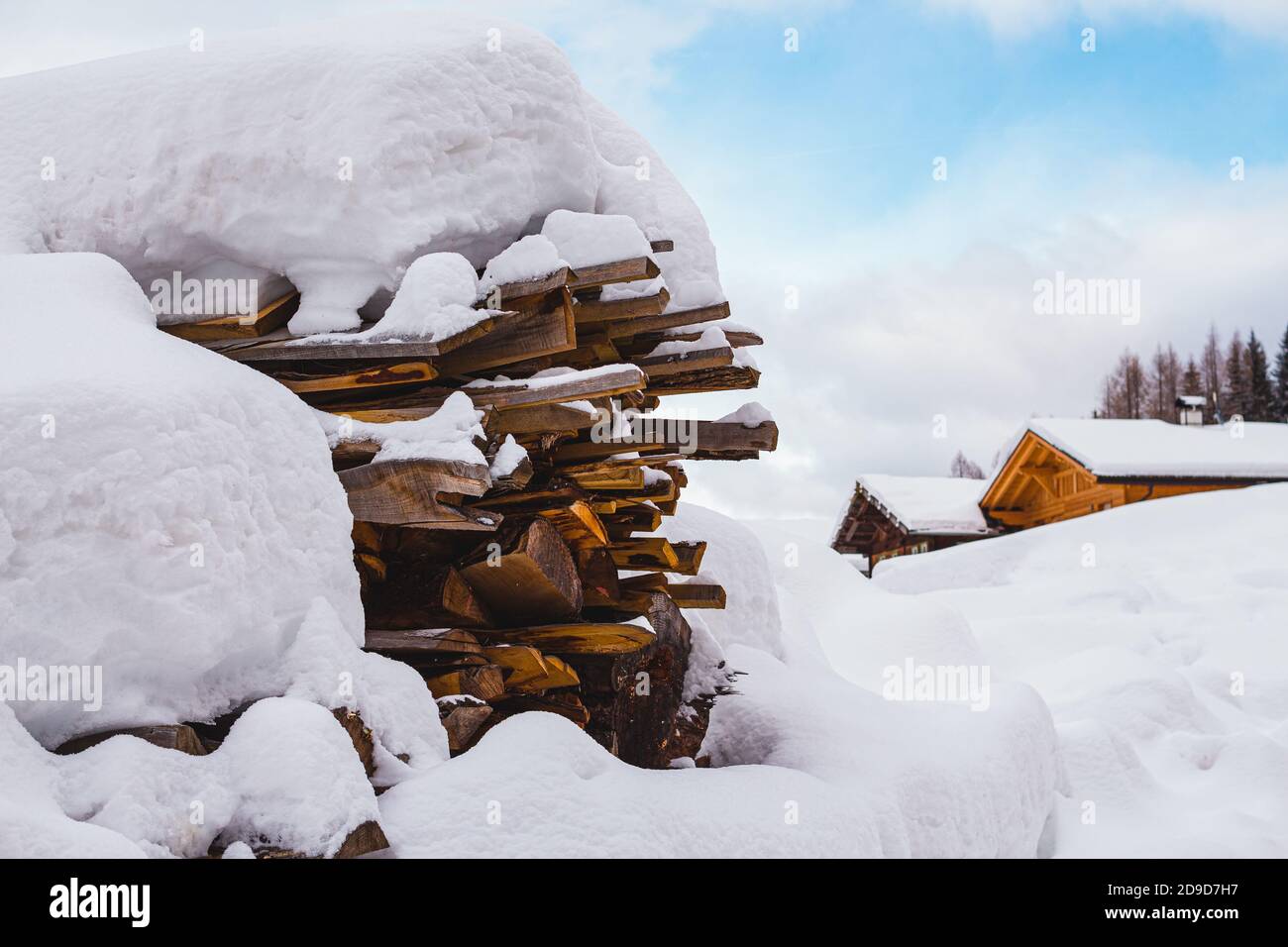snow covered wood stack and traditional wooden mountain huts in St. Gertraud (Ultental,South Tyrol/Italy) on cold Winter day Stock Photo