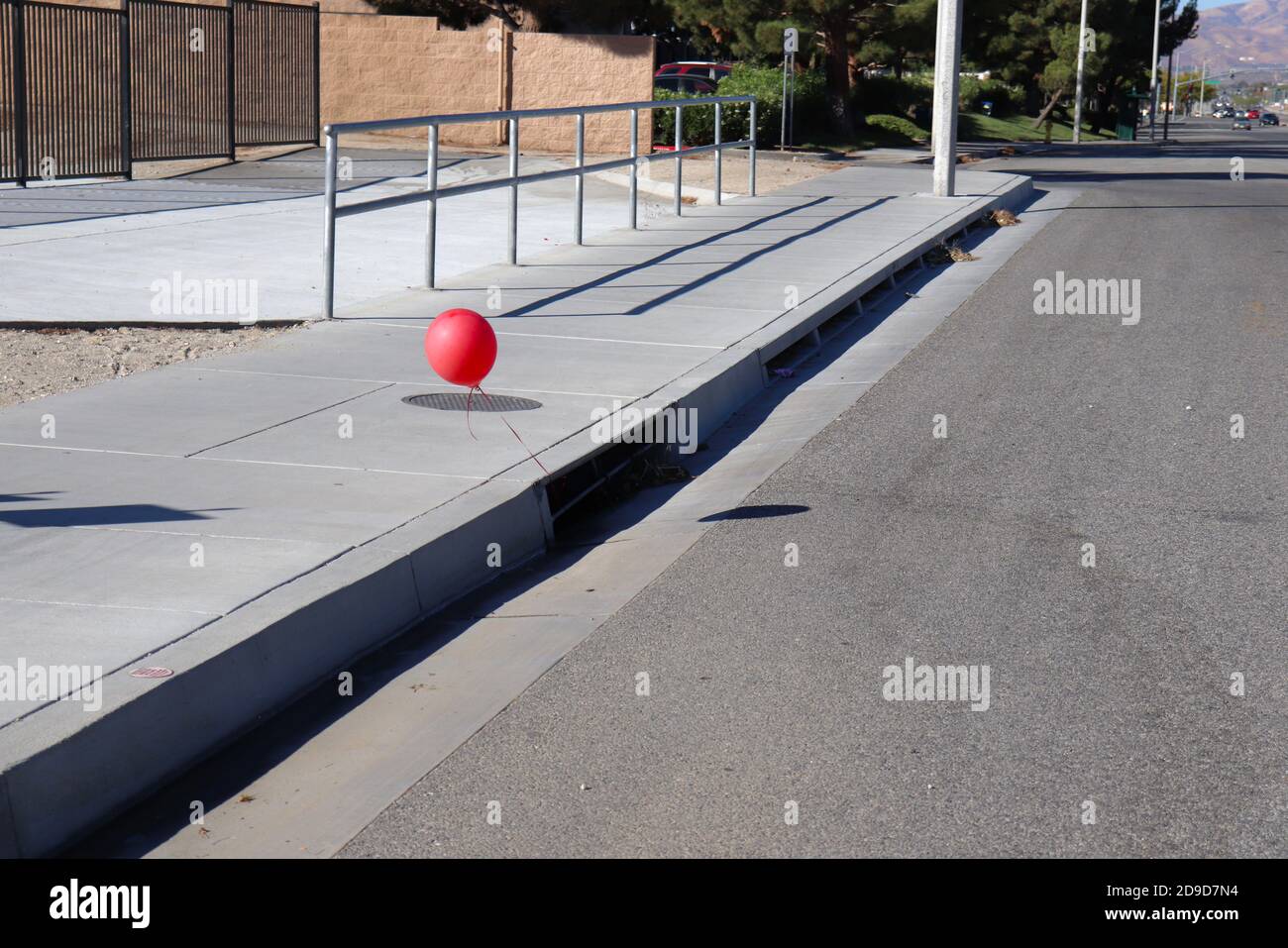 Red balloon hanging from storm drain Stock Photo Alamy
