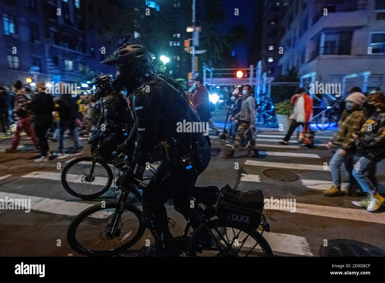 New York, New York, US. Nov 4th 2020. As the US awaits election results, bicycle-mounted police in body armor ride alongside anti-Trump protesters marching through New York City's Greenwich Village neighborhood Stock Photo