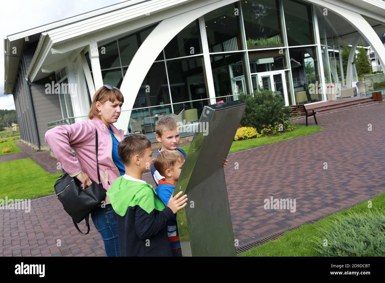 Family look at map of park in summer Stock Photo