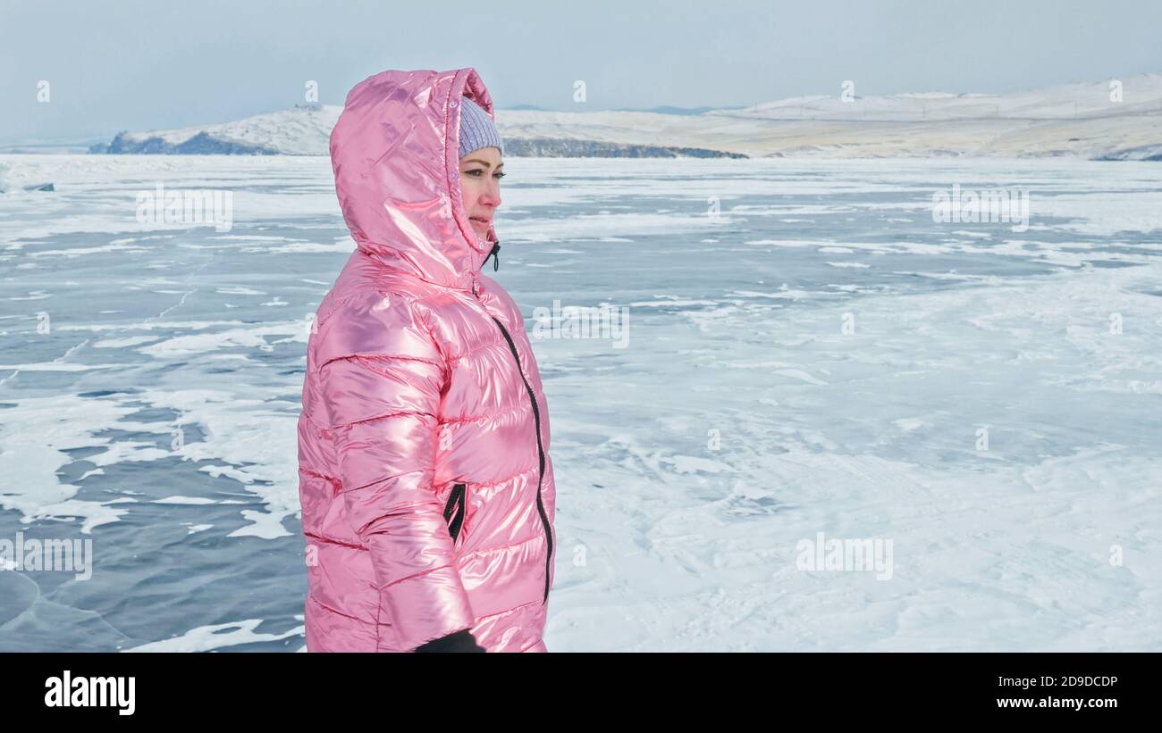 Girl walking on cracked ice of a frozen lake Baikal. Woman trave Stock Photo