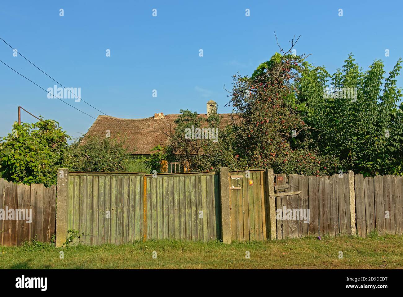 Old worn wooden fence around a farm with orchard in the Romanian ...