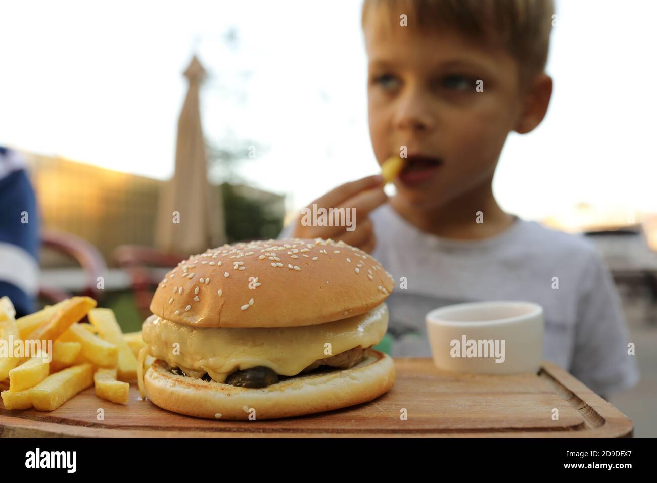 Boy eating fries and burger in restaurant Stock Photo Alamy