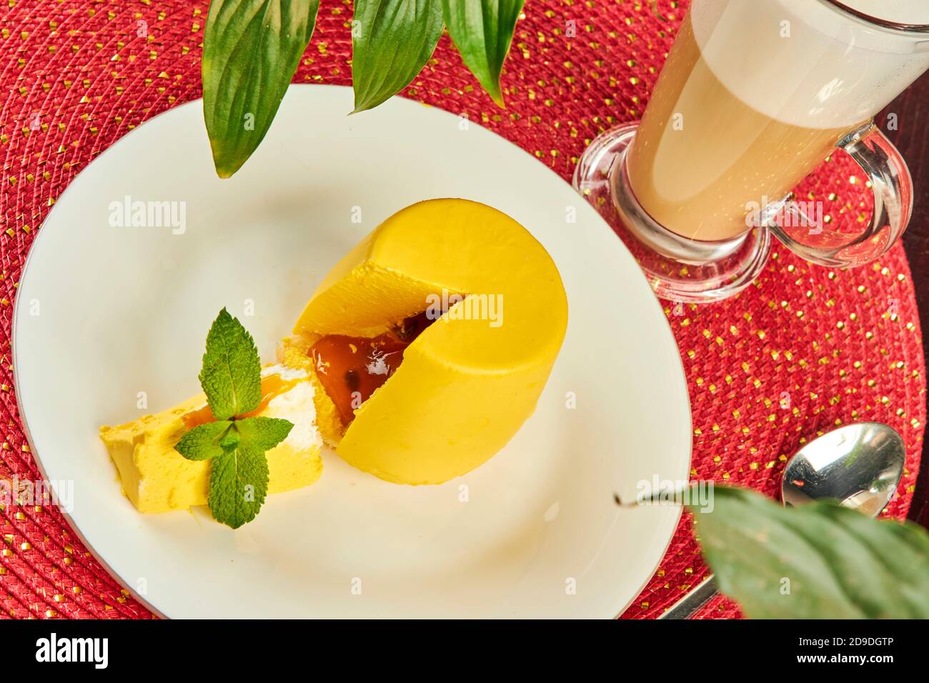 Yellow mini cake covered with yellow glaze on table in cafe close up Stock Photo