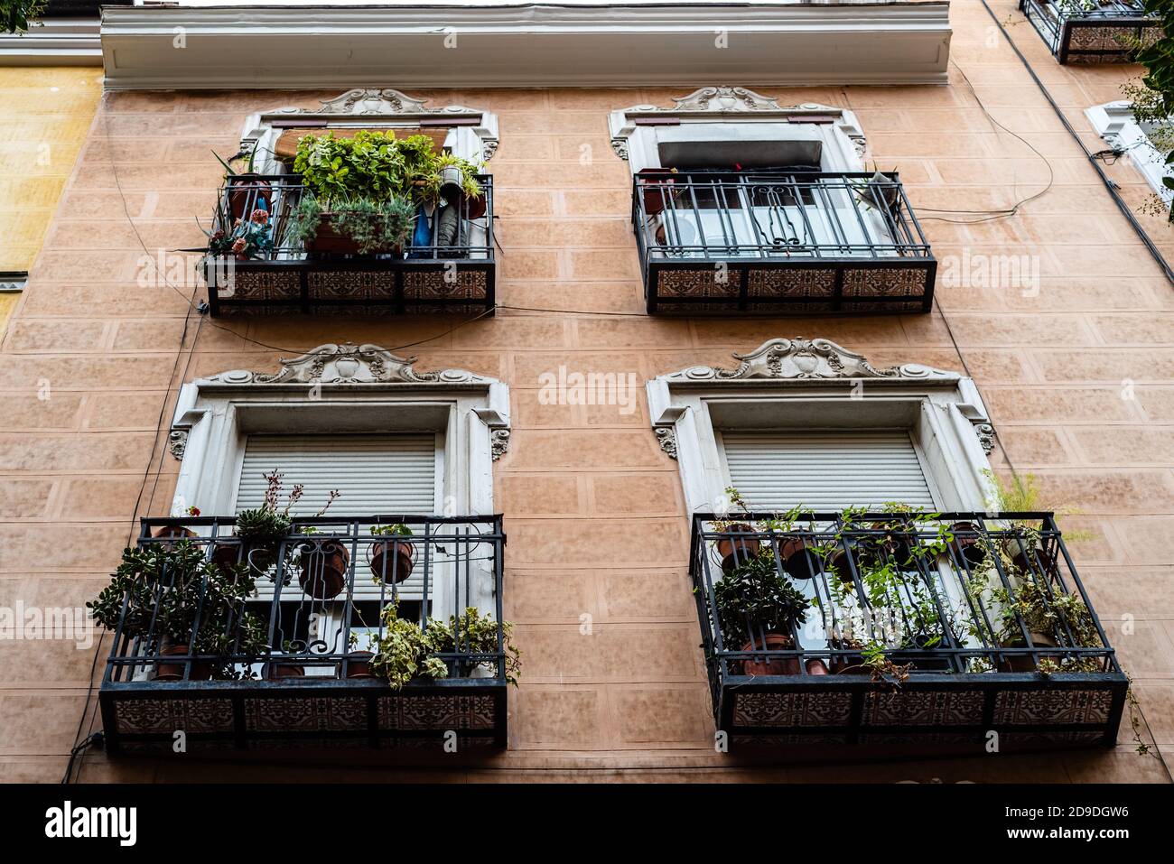 Low angle view of traditional cast iron balconies of old residential building in Lavapies quarter in central Madrid Stock Photo