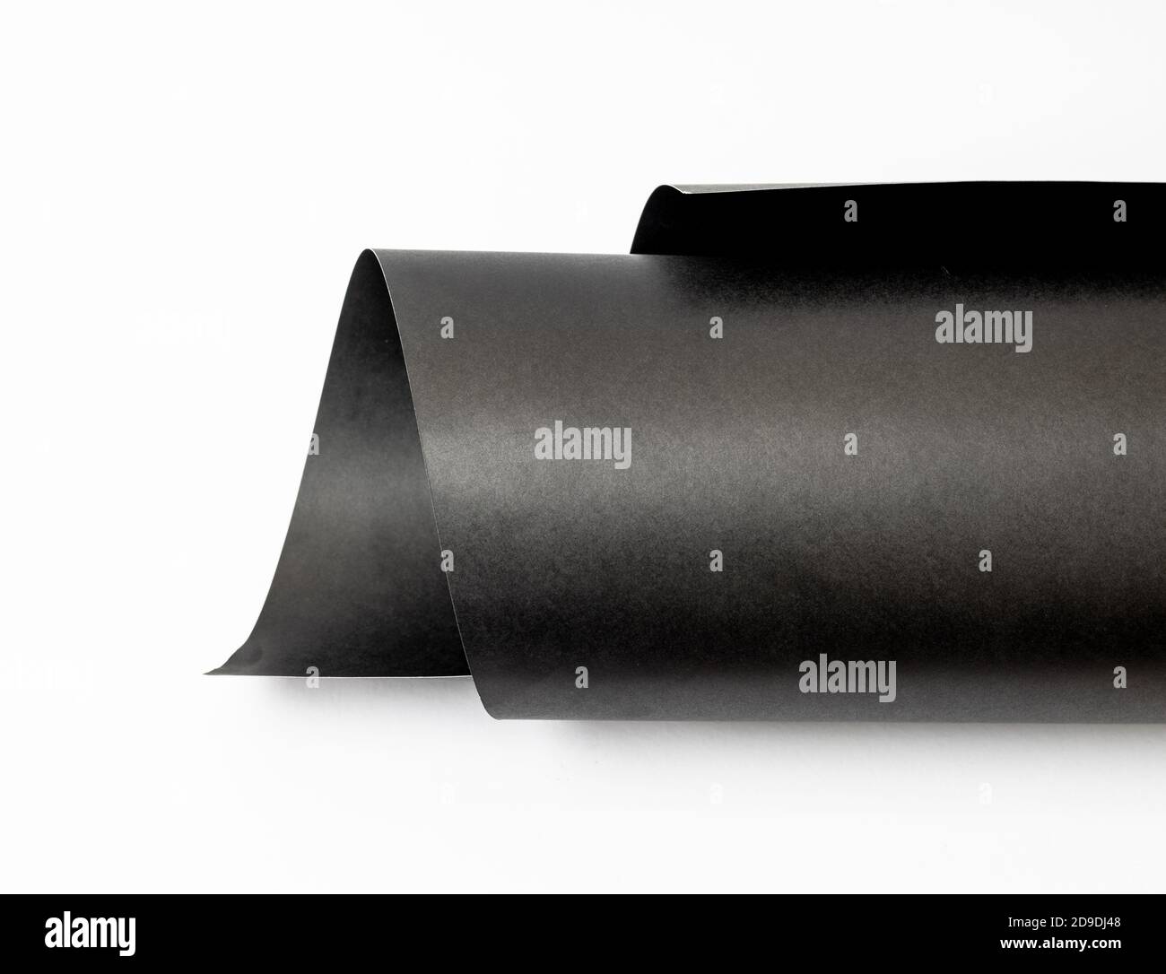 Rolled black art paper isolated on white background Stock Photo