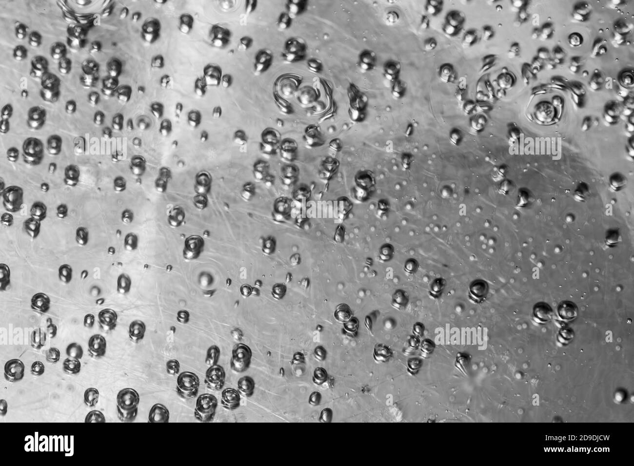 Closeup of air bubbles on the water surface, water boils in a steel tank, selective focus, top view, copy space Stock Photo