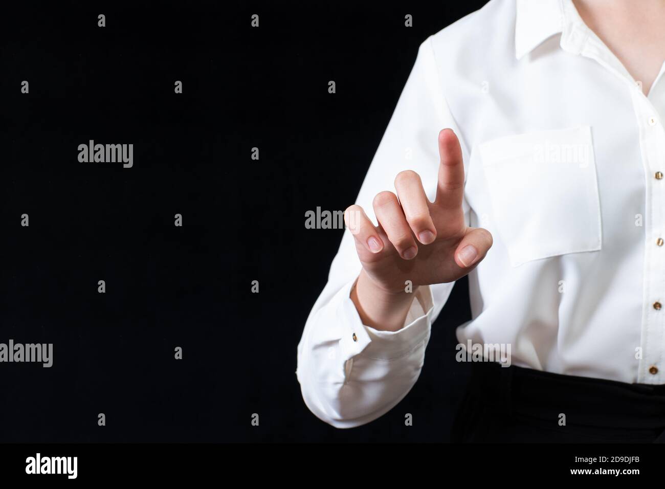 Businesswoman in front of visual touchscreen, isolated on black background. Business concept. Online learning Stock Photo