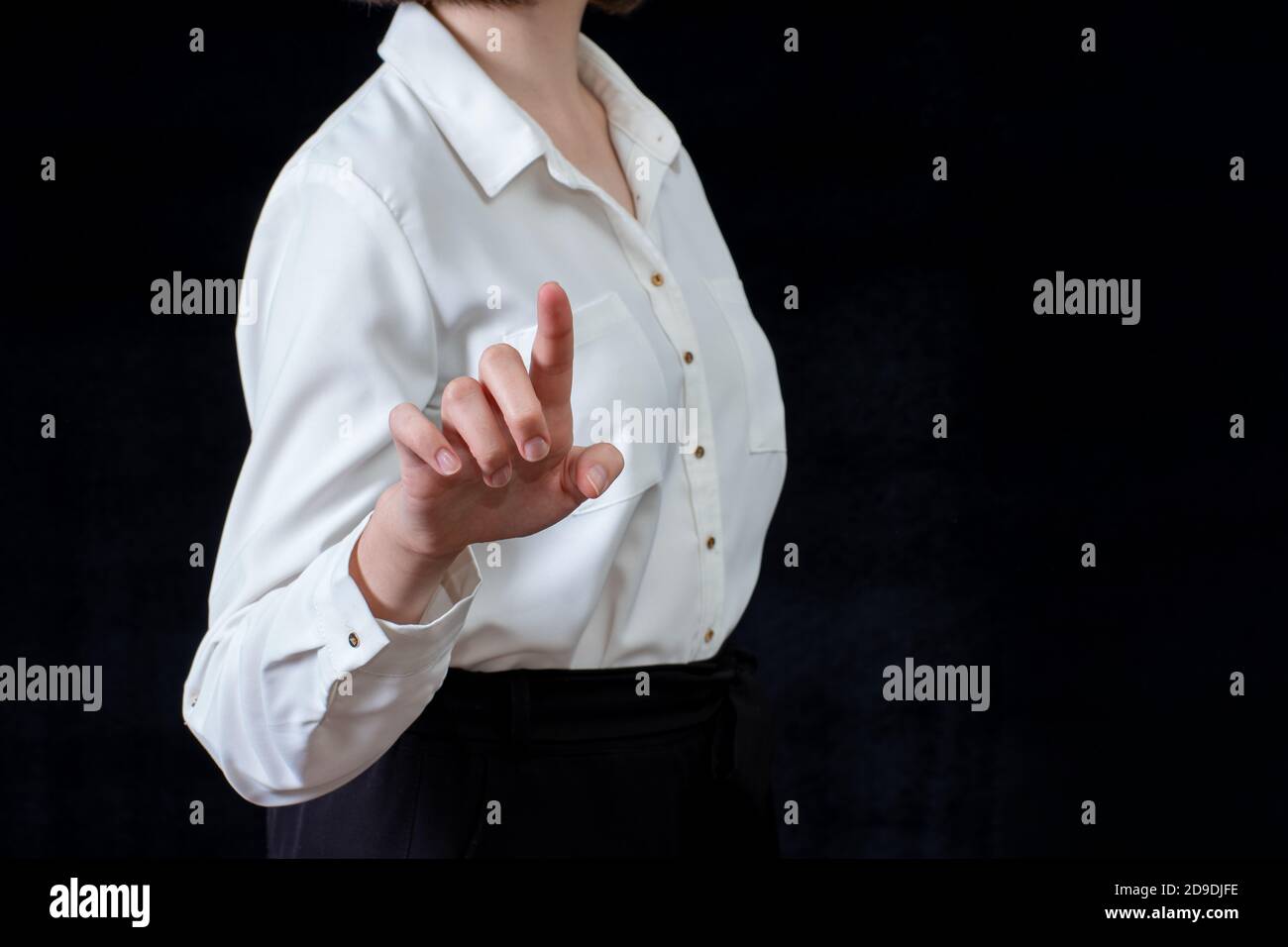 Businesswoman in front of visual touchscreen, isolated on black background. Business concept. Online learning Stock Photo