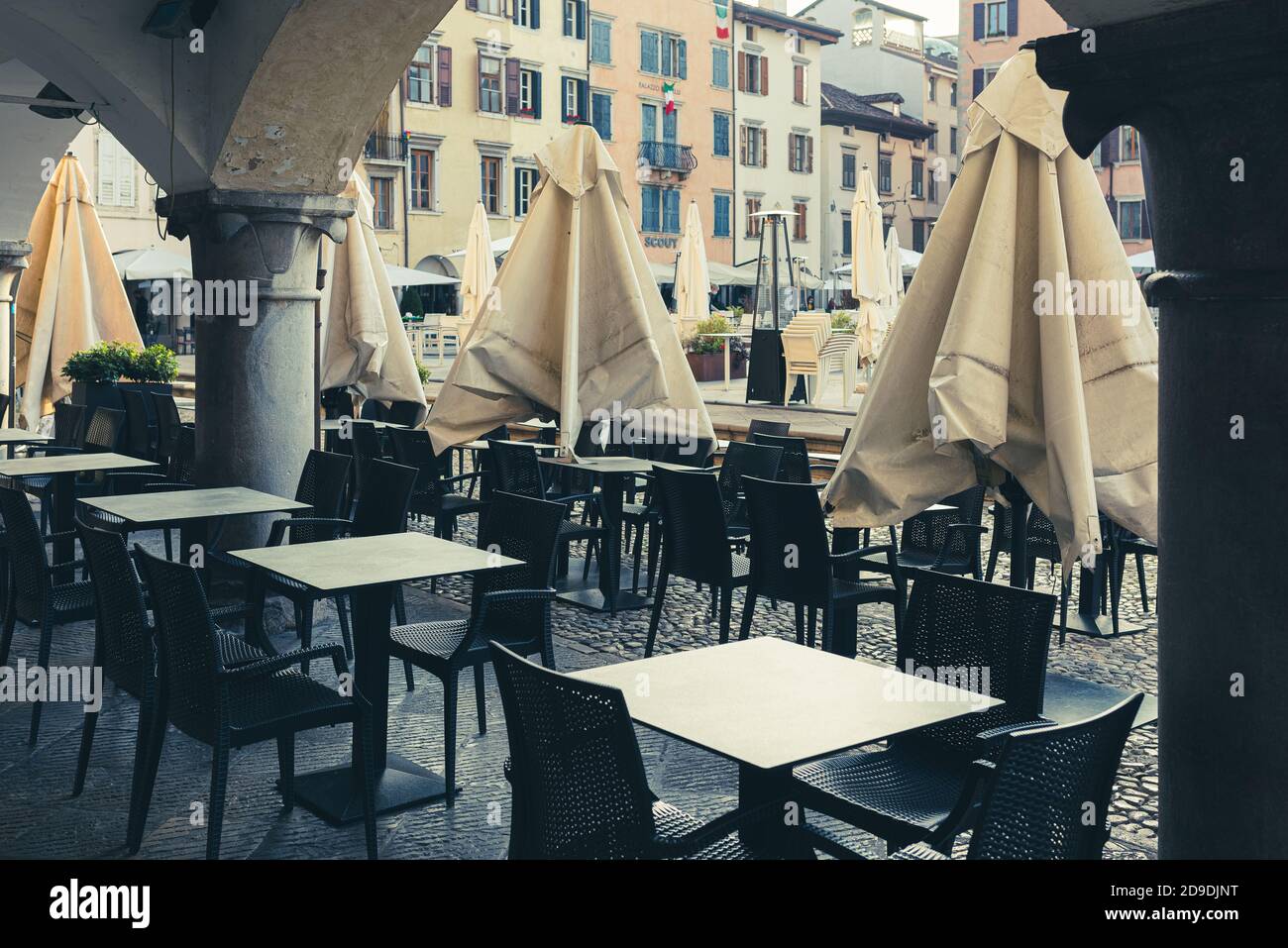 Empty café tables on an an Italian historical square. Coronavirus forces people to stay safe at home. Stock Photo