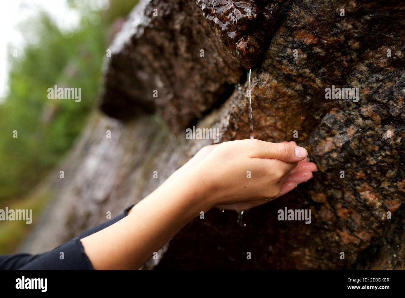 Close up water dripping from rock onto hands Stock Photo Alamy