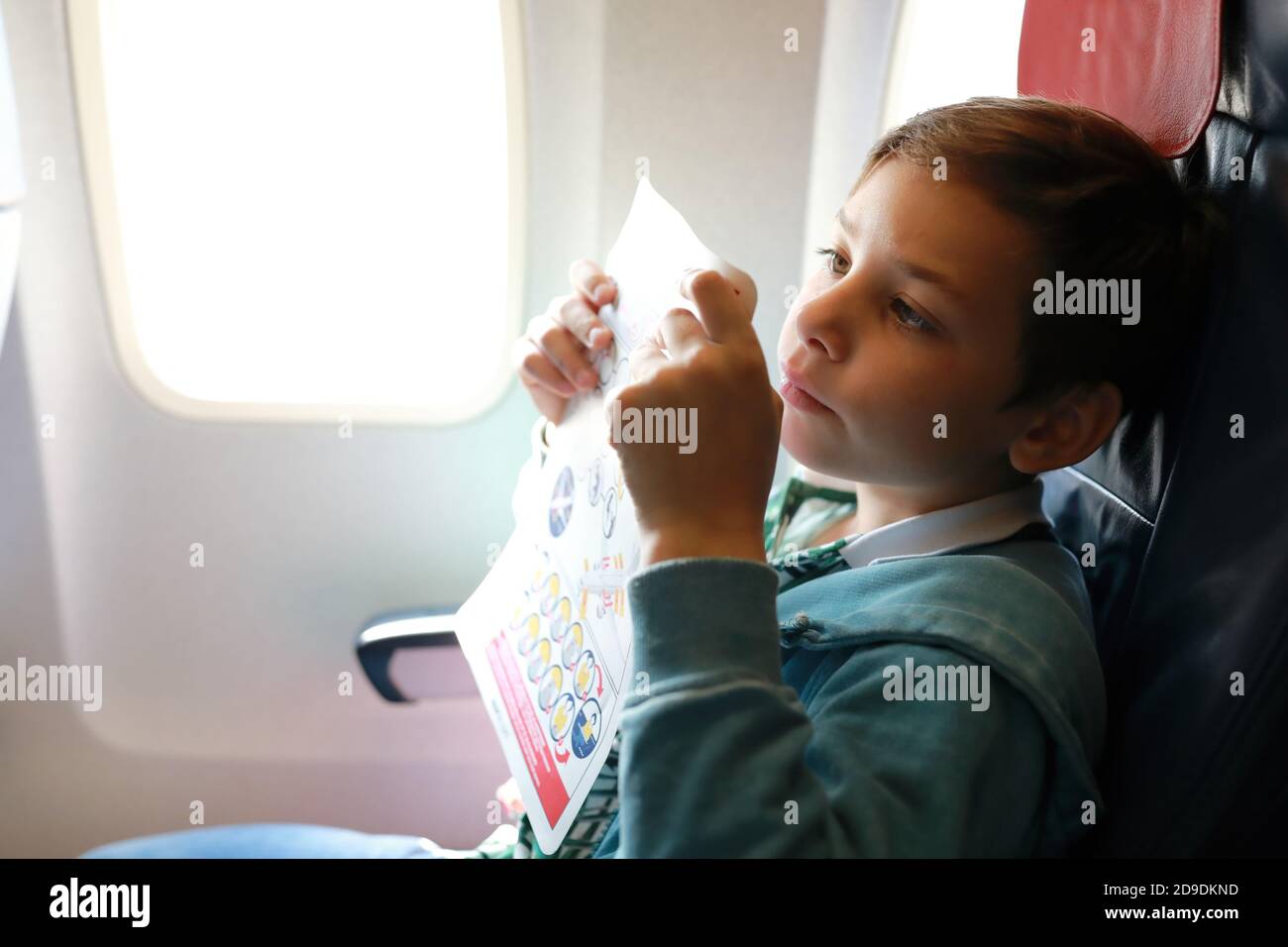 Child studying flight safety instructions on board aircraft Stock Photo Alamy