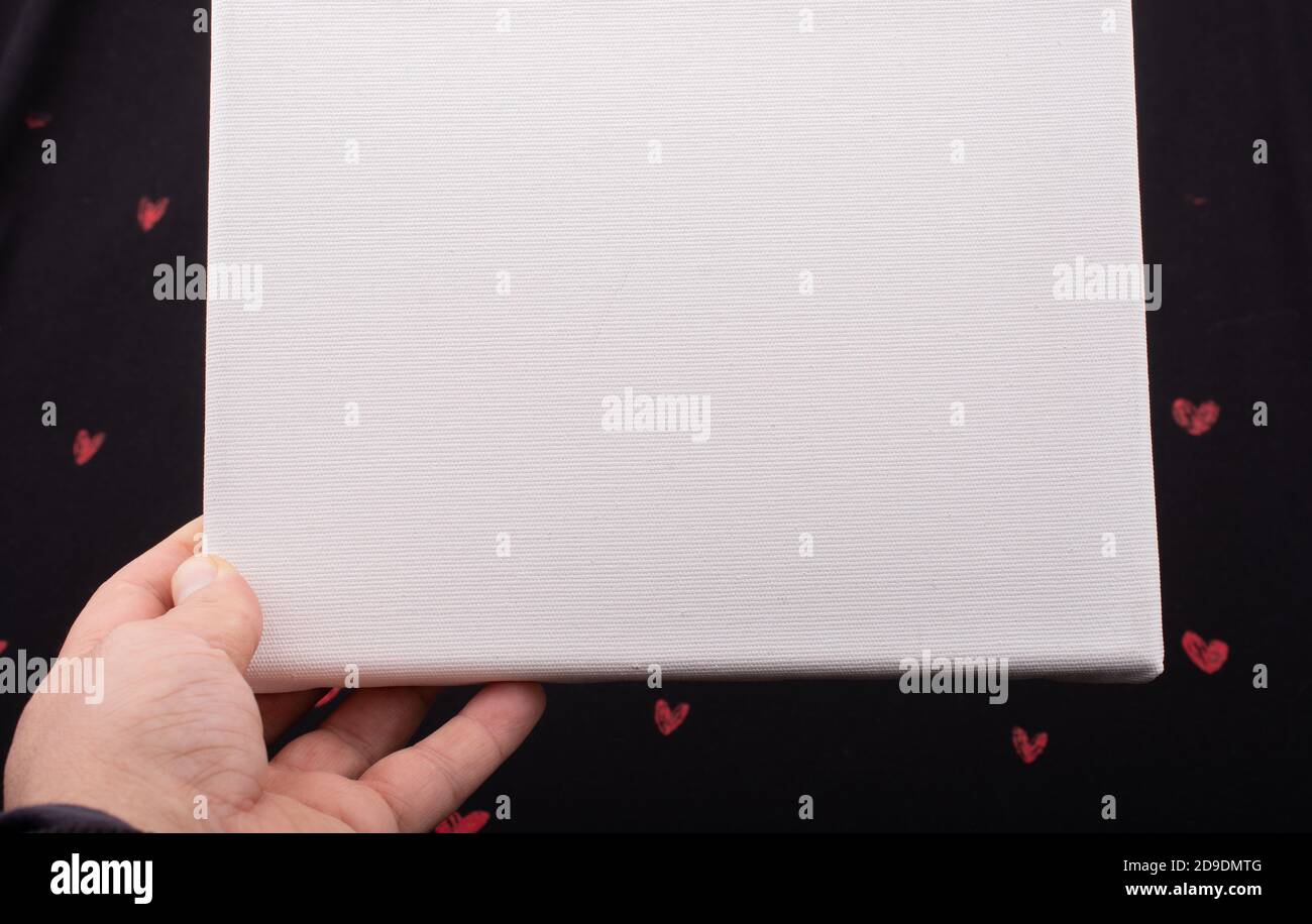 White blank canvas on black background with red hearts Stock Photo