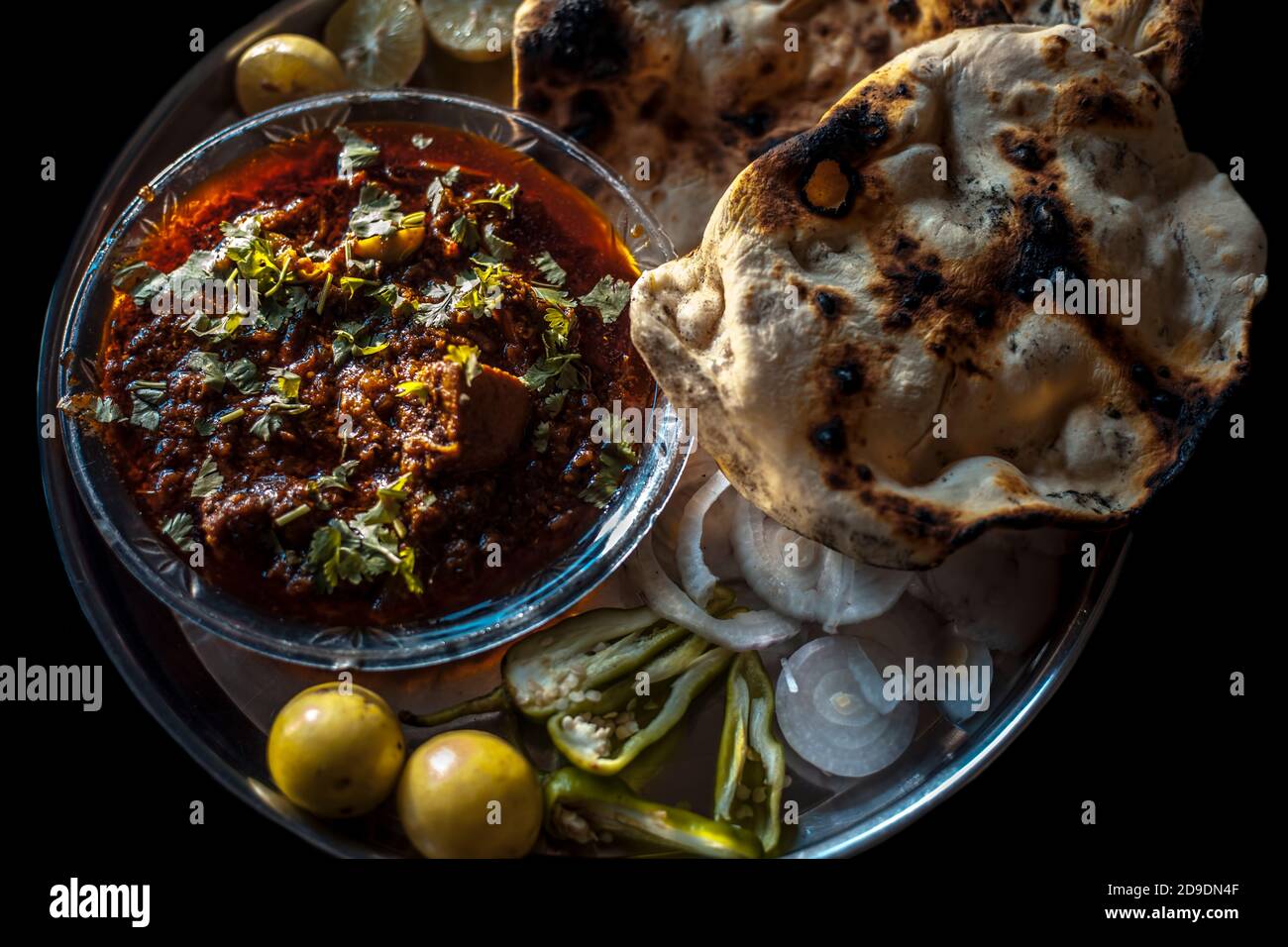 Shot of Achari Chicken along with tandoori roti with it on a serving ...