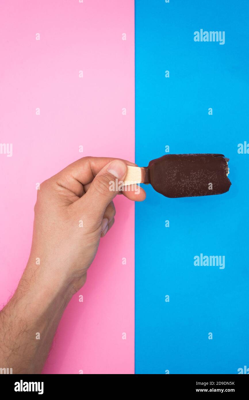 hand holding a chocolate and mint ice cream, with two colors, blue and