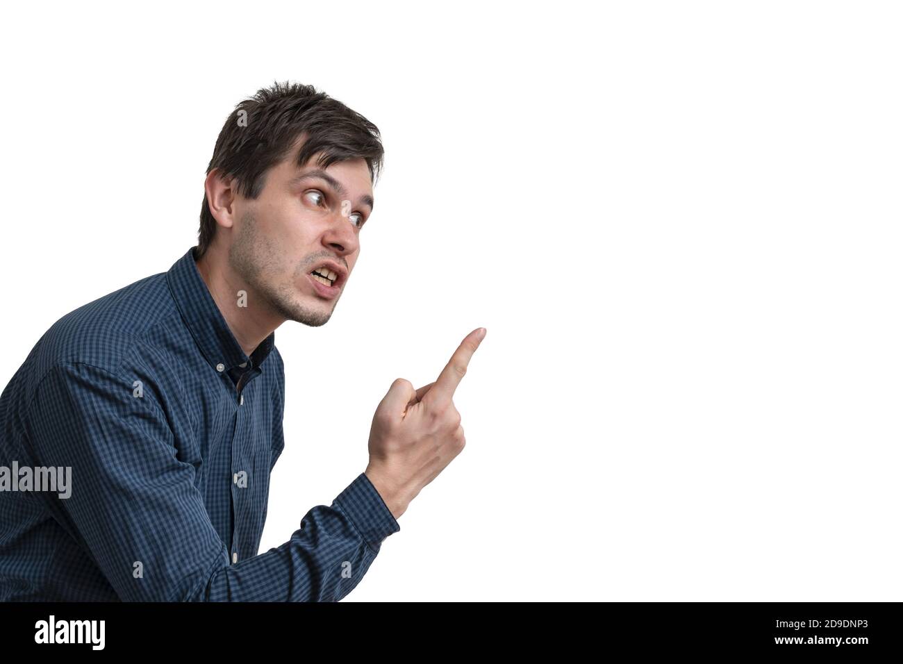 Young angry man threatening with finger isolated on white background. Side view. Stock Photo