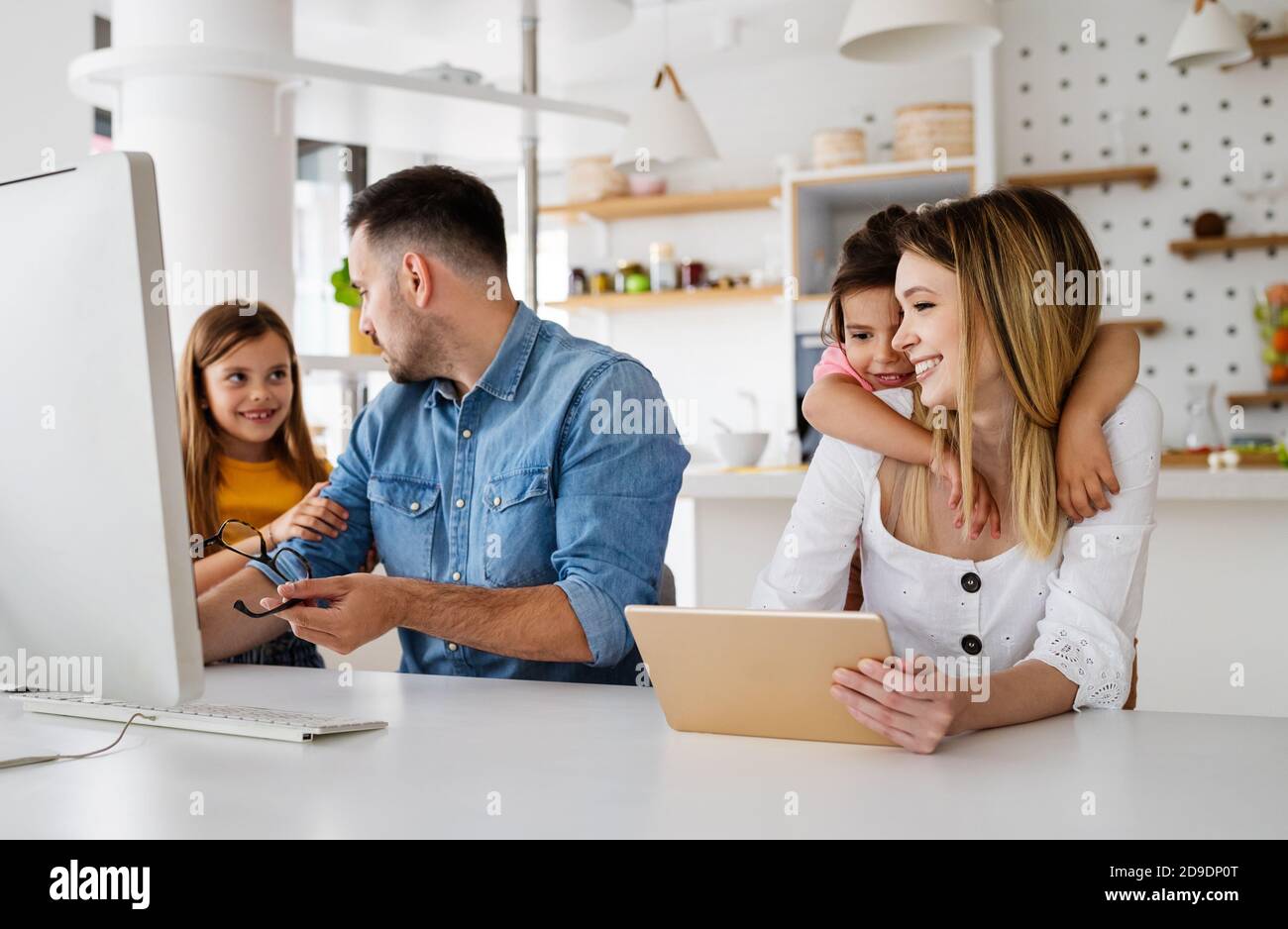 Business parents interrupts by her children while working in home office Stock Photo