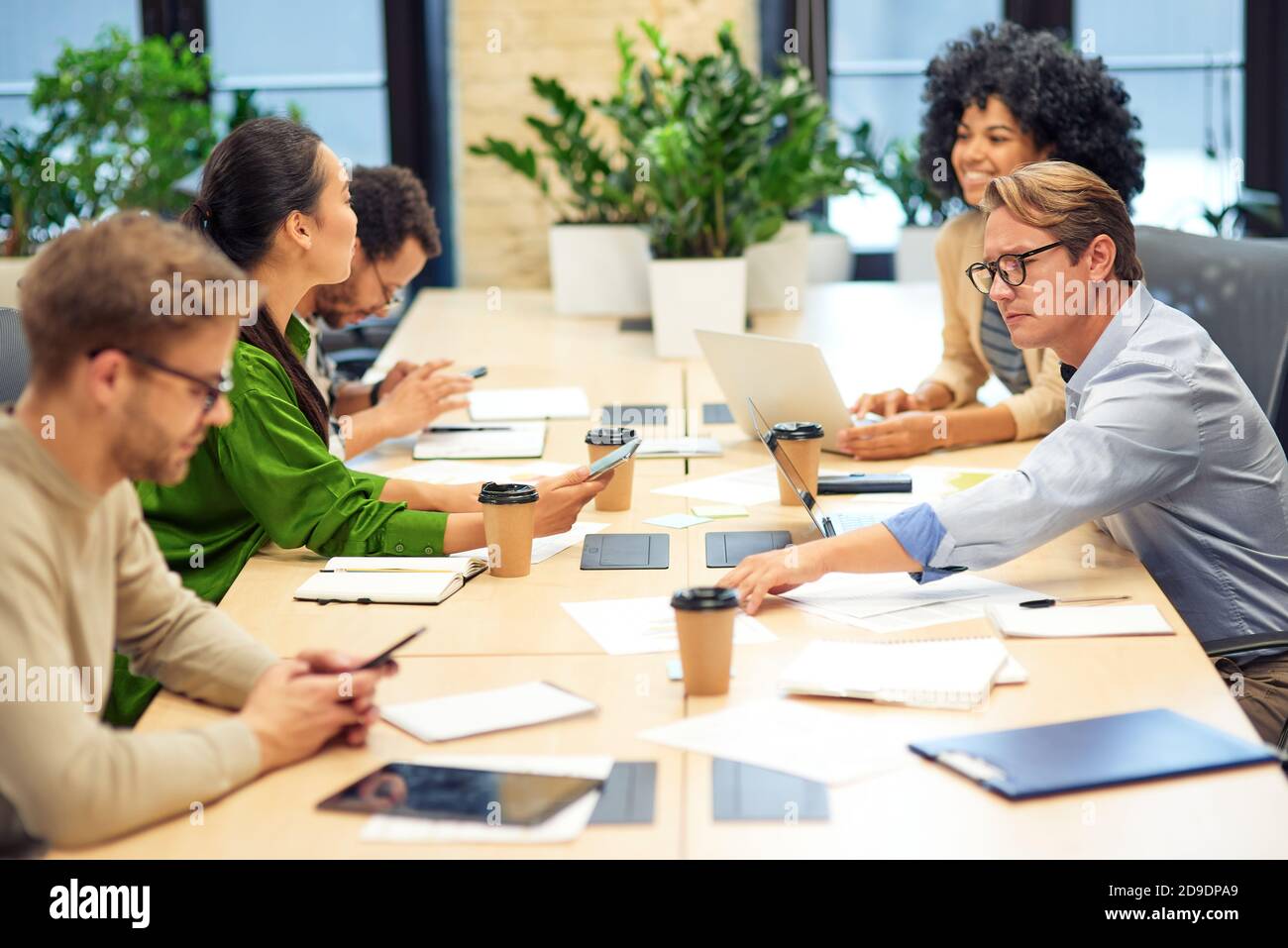 Brainstorming meeting. Group of multiracial colleagues sitting in board room in the modern office and working together. Teamwork and collaboration concept Stock Photo