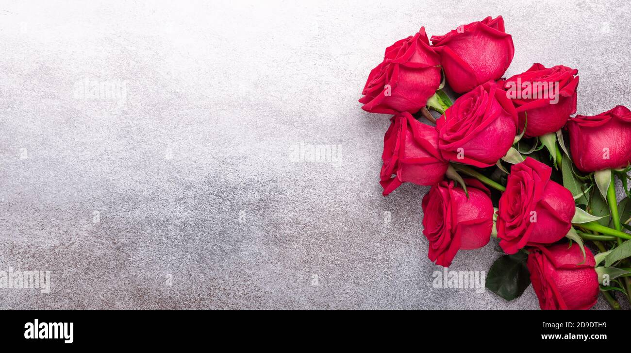 Horizontal banner with bouquet of red roses on stone background. Valentines day greeting card - Image Stock Photo