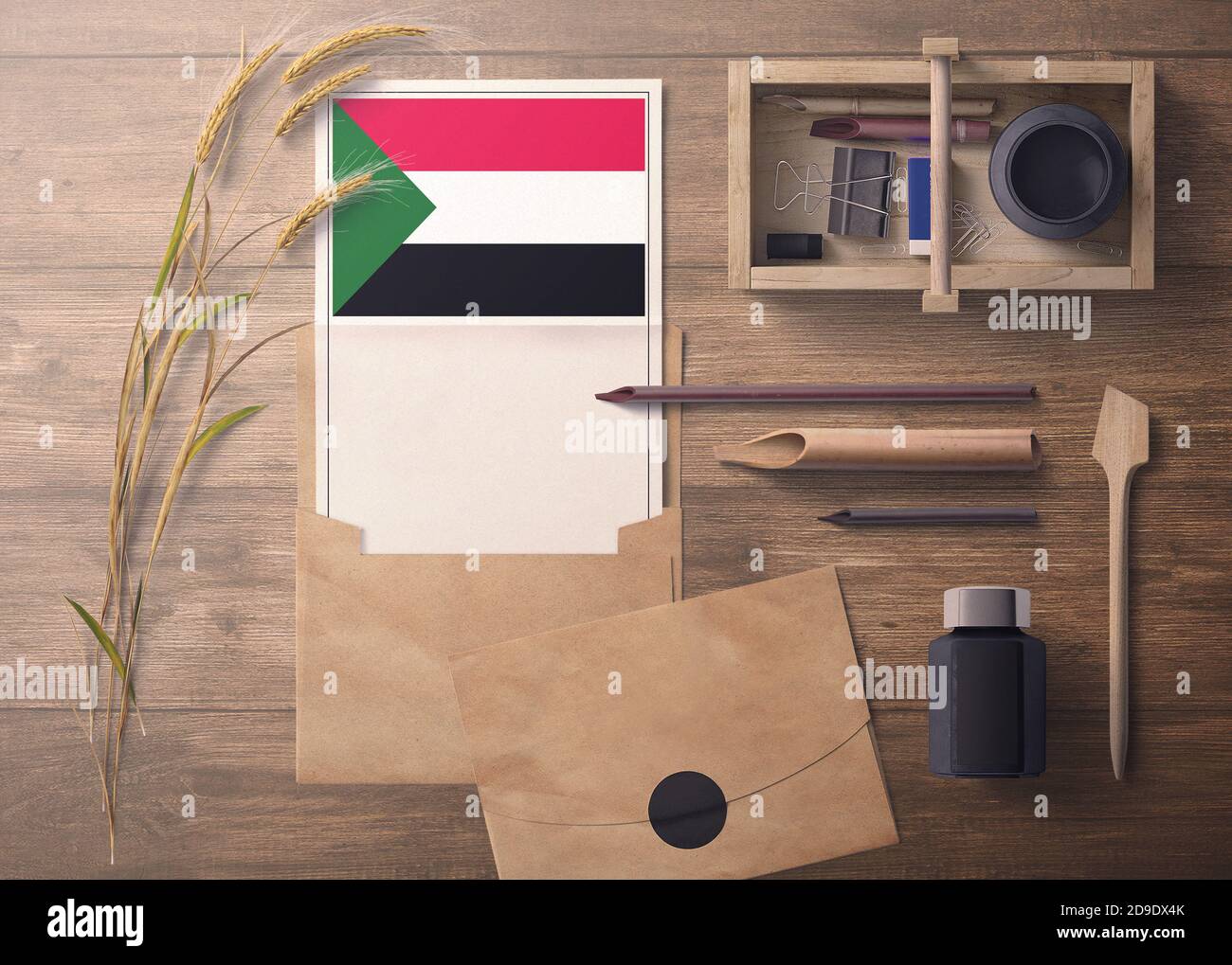 Sudan invitation, celebration letter concept. Flag with craft paper and envelope. Retro theme with divide, ink, wooden pen objects. Stock Photo