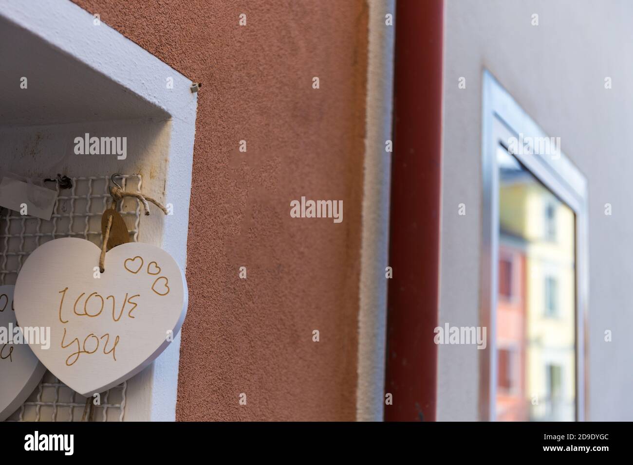 Decorative heart with I love you caption on it hanging near a wall
