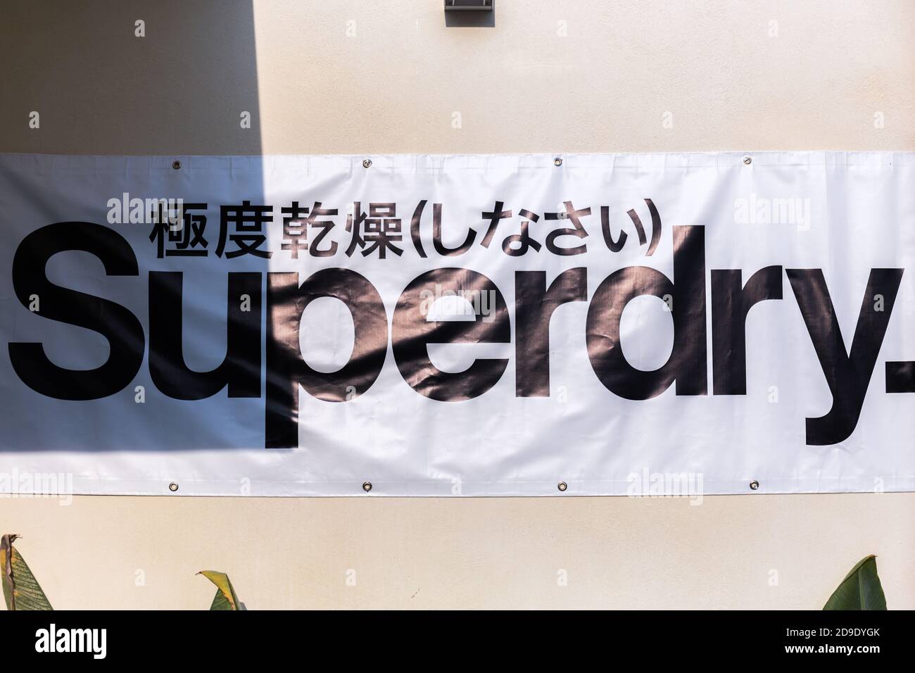 Superdry caption hanging on a wall on white background name of famous  clothing company Stock Photo - Alamy