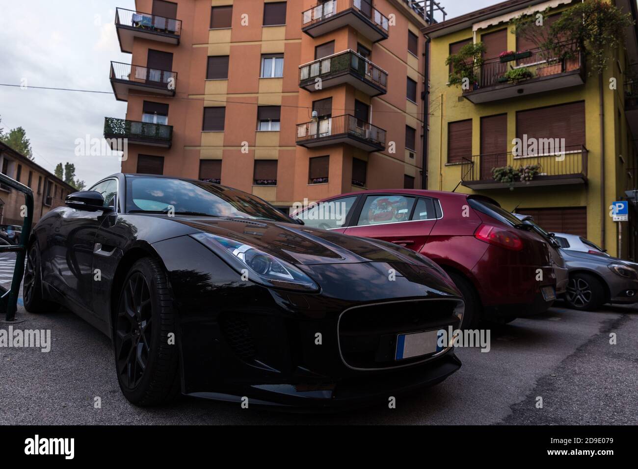 Sportive expensive car parked in a poor neighbourhood. Wealth concept Stock Photo