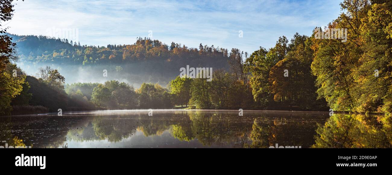 Lake fog landscape with Autumn foliage and tree reflections in Styria, Thal, Austria Stock Photo