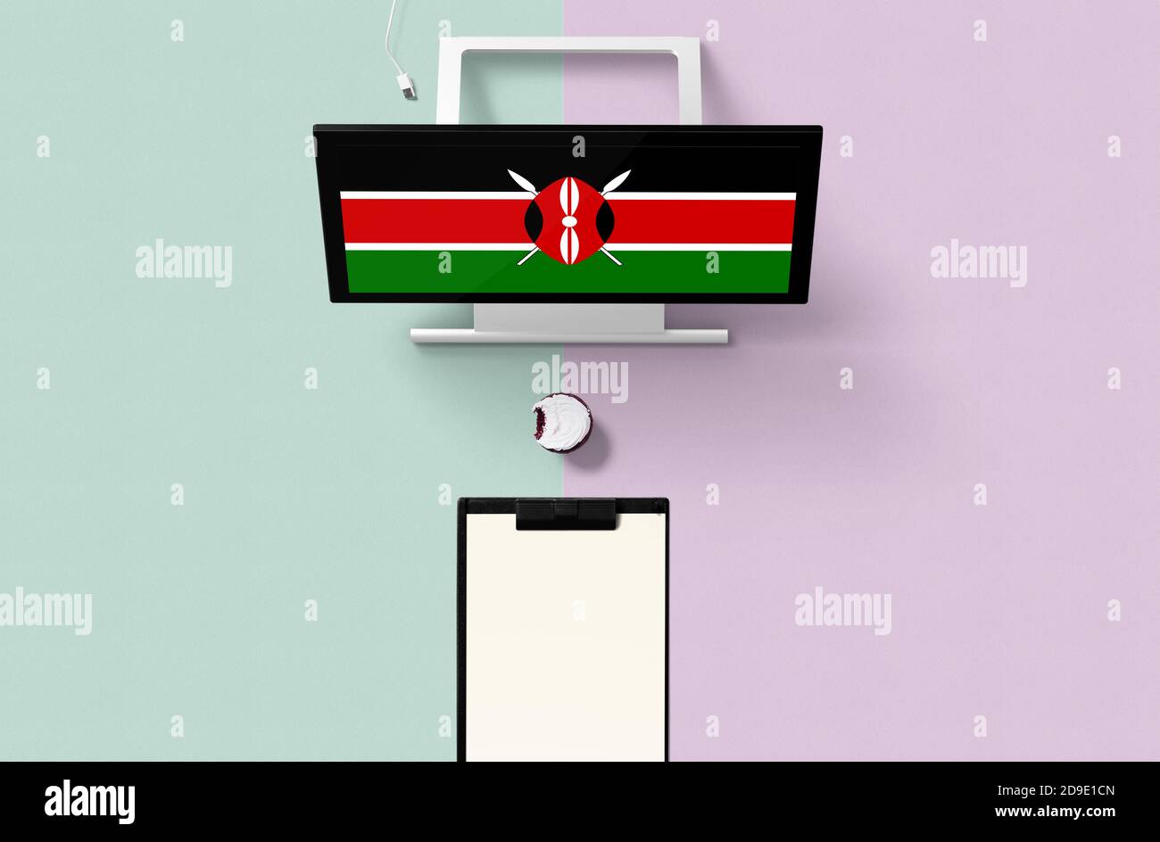 Kenya national flag on computer screen top view, cupcake and empty note