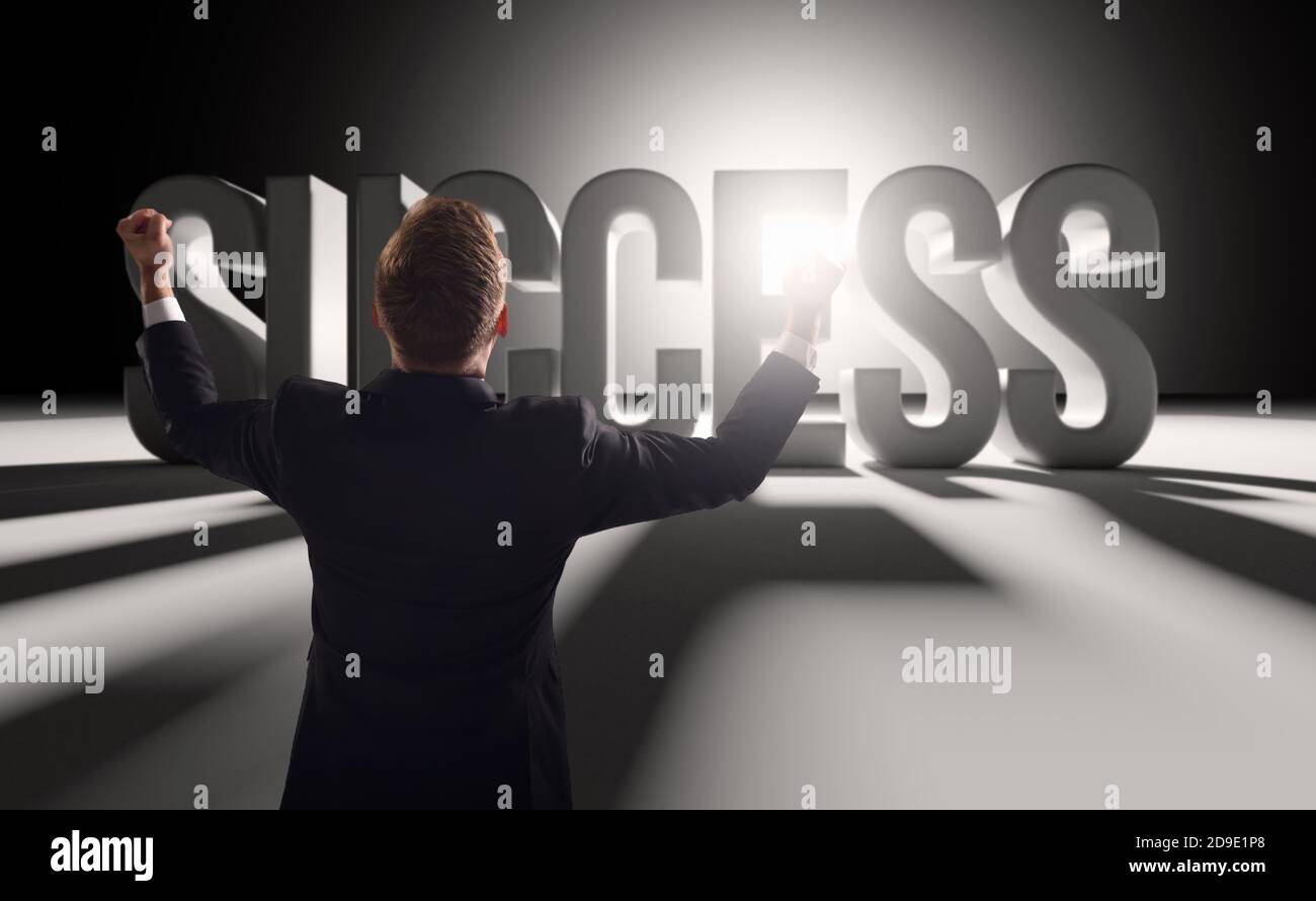 Excited businessman achieved success raising his hands up with joy against the background of the word success Stock Photo