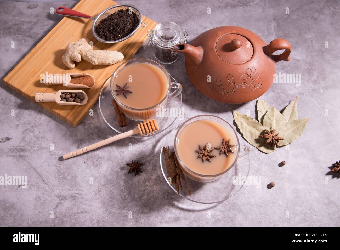 Indian tea masala tea. Tea with milk and spices in wooden spoons on a wooden cutting Board. Horizontal orientation Stock Photo