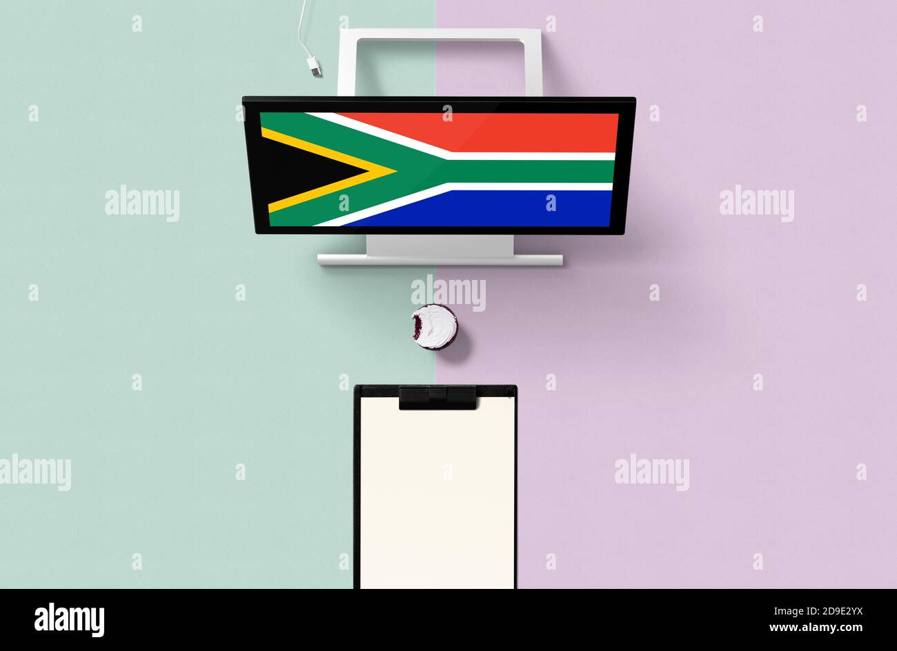 South Africa national flag on computer screen top view, cupcake and empty note paper for planning. Minimal concept with turquoise and purple backgroun Stock Photo