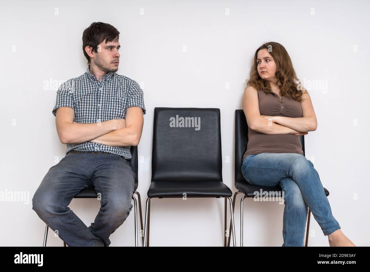 Divorce and relationship difficulties concept. Man and woman sitting on chairs and looking at each other. Stock Photo