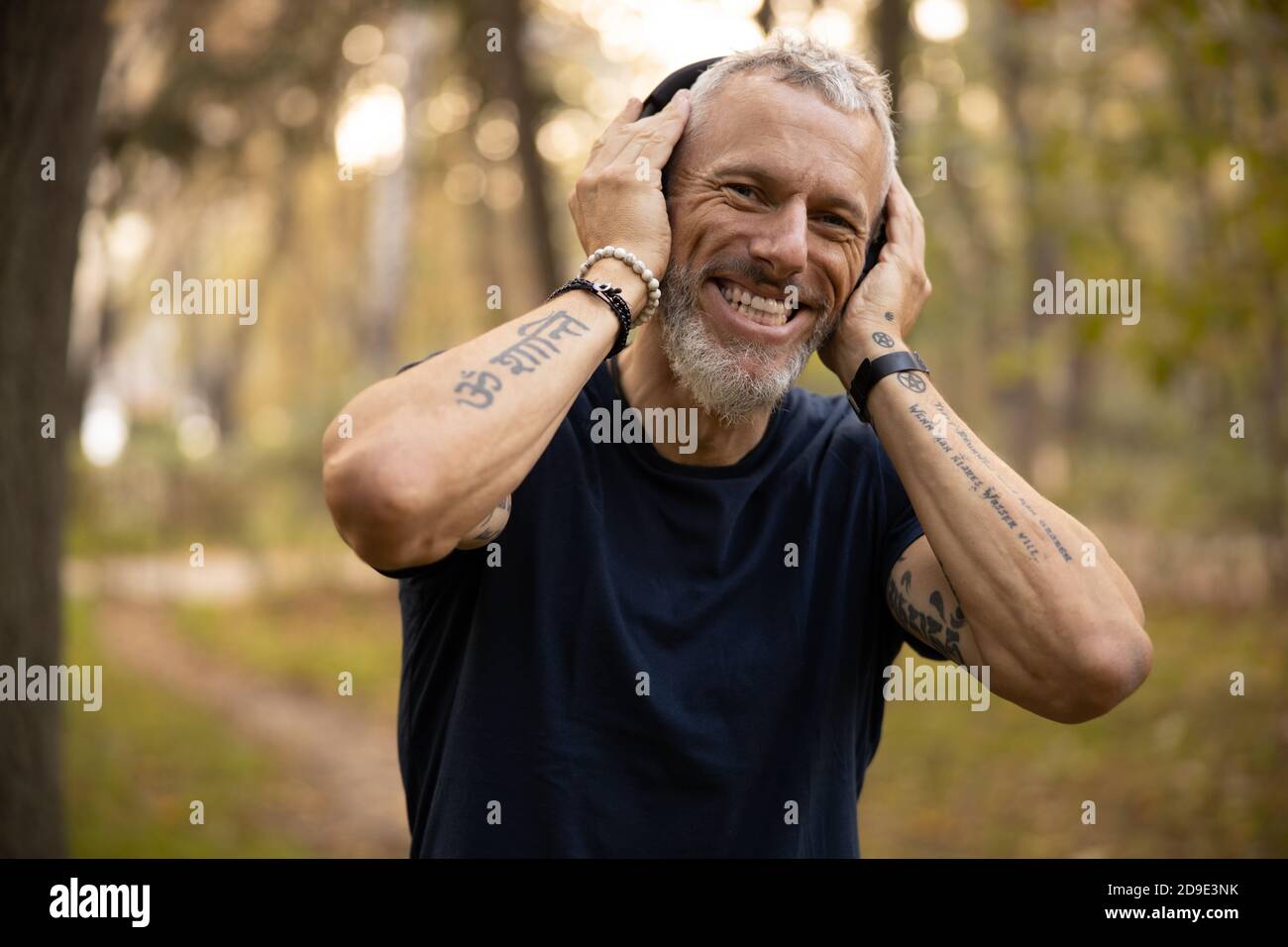 Happy active man going jogging in park Stock Photo