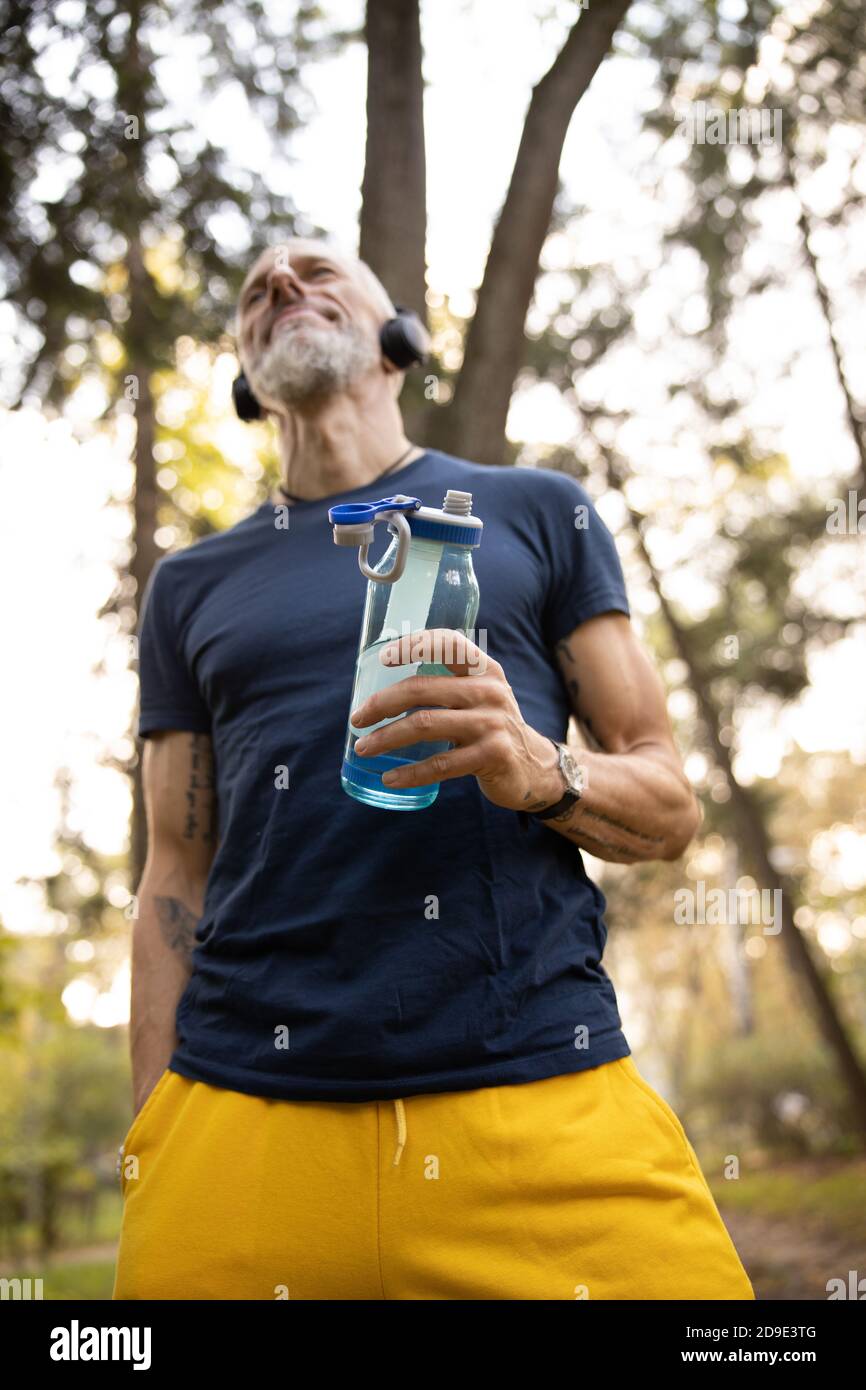Smiling bearded male relaxing after workout outdoors Stock Photo