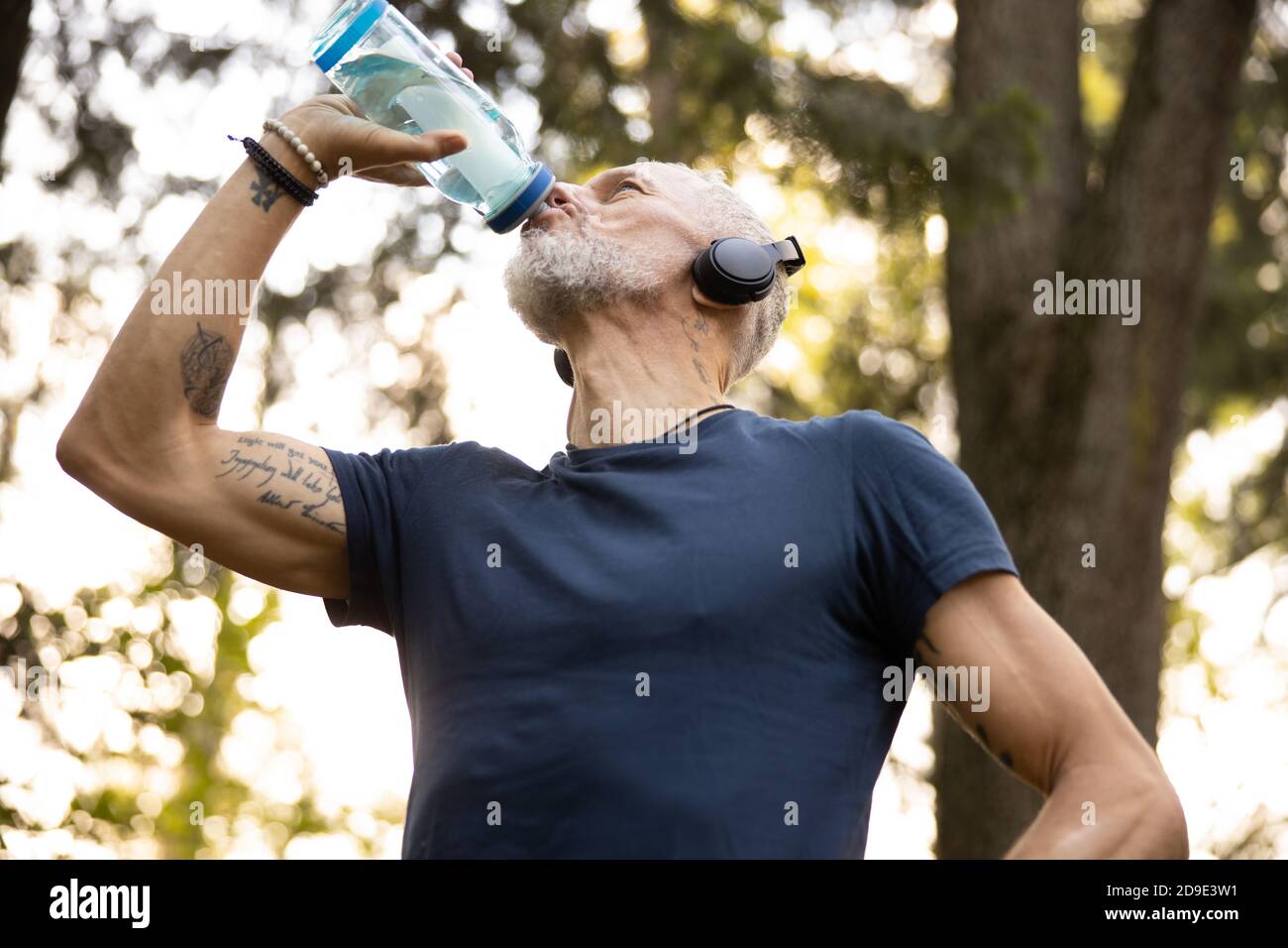 Athletic male quenching thirst during workout outdoors Stock Photo