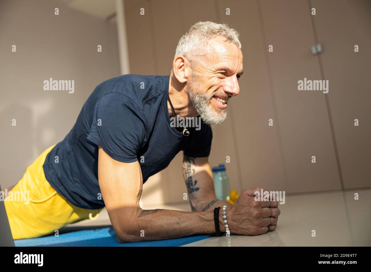 Athletic male doing a plank on a blue cover Stock Photo