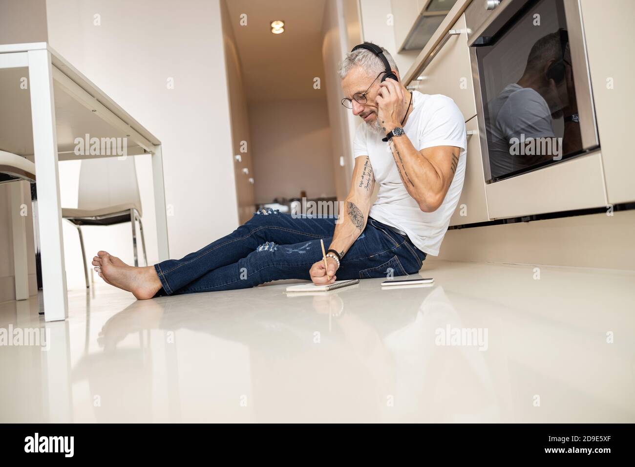 Man talking through headset and writing down in notepad Stock Photo
