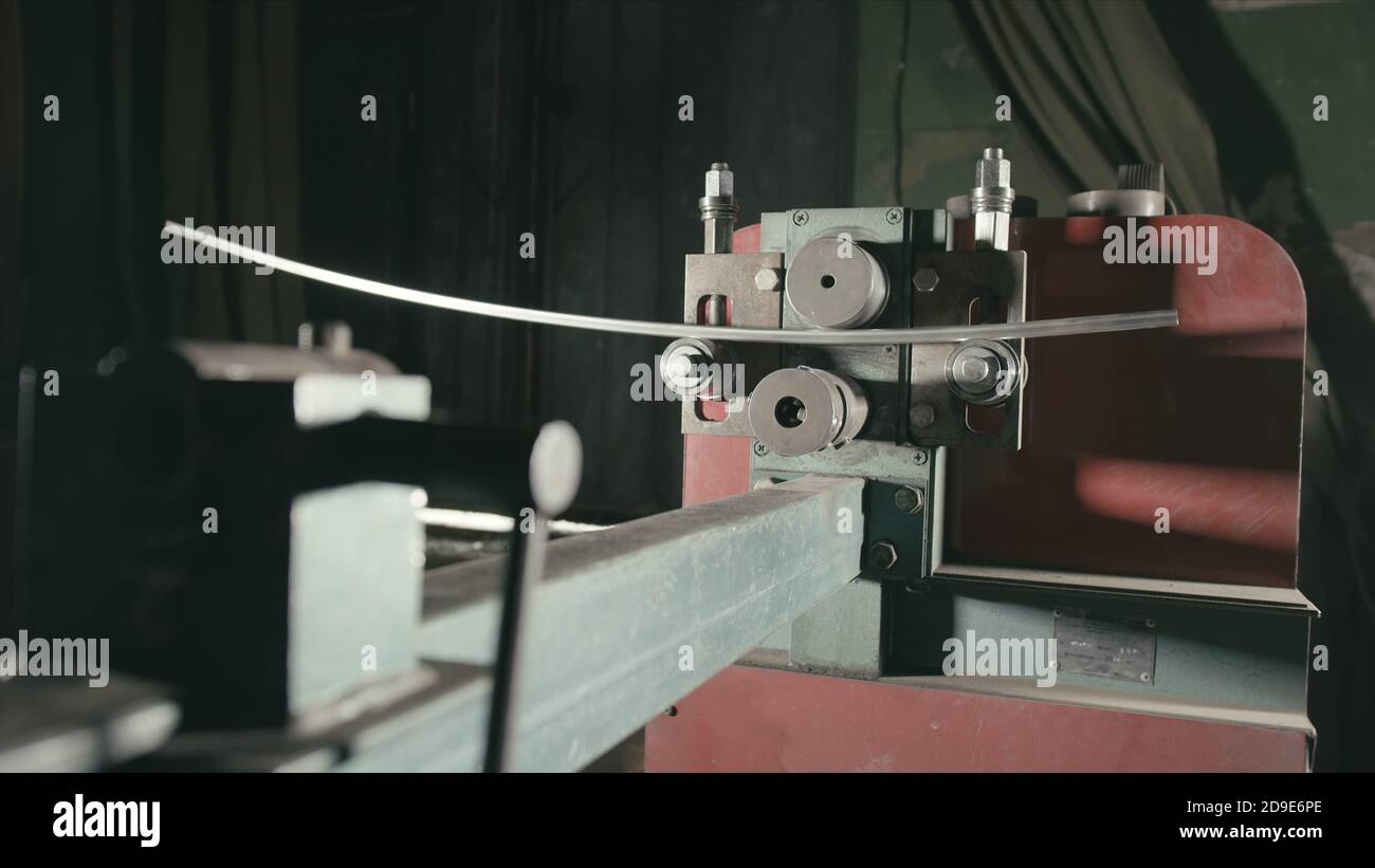 on table. Worker bends the metal rod on the wrought iron