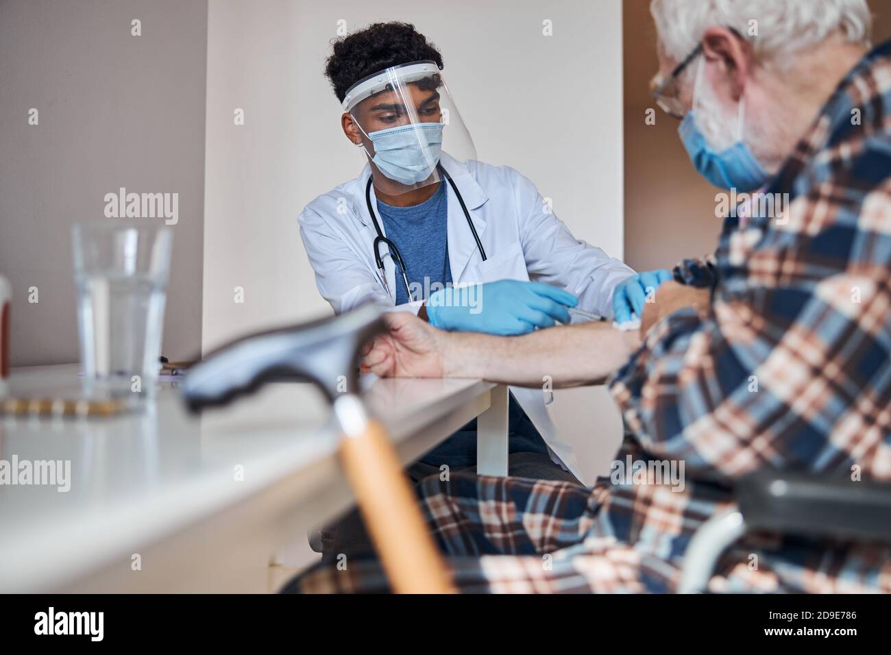 Skilled physician injecting insulin to an elderly man Stock Photo
